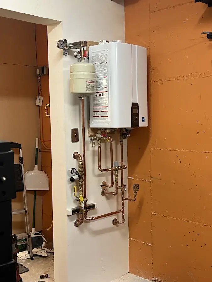 Plumbing technician inspecting water heater connections in Pickens